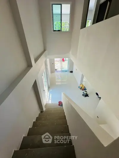 Spacious modern interior with high ceilings and large windows, showcasing a bright and airy atmosphere.