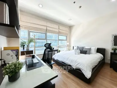 Modern bedroom with workspace and large windows in urban apartment