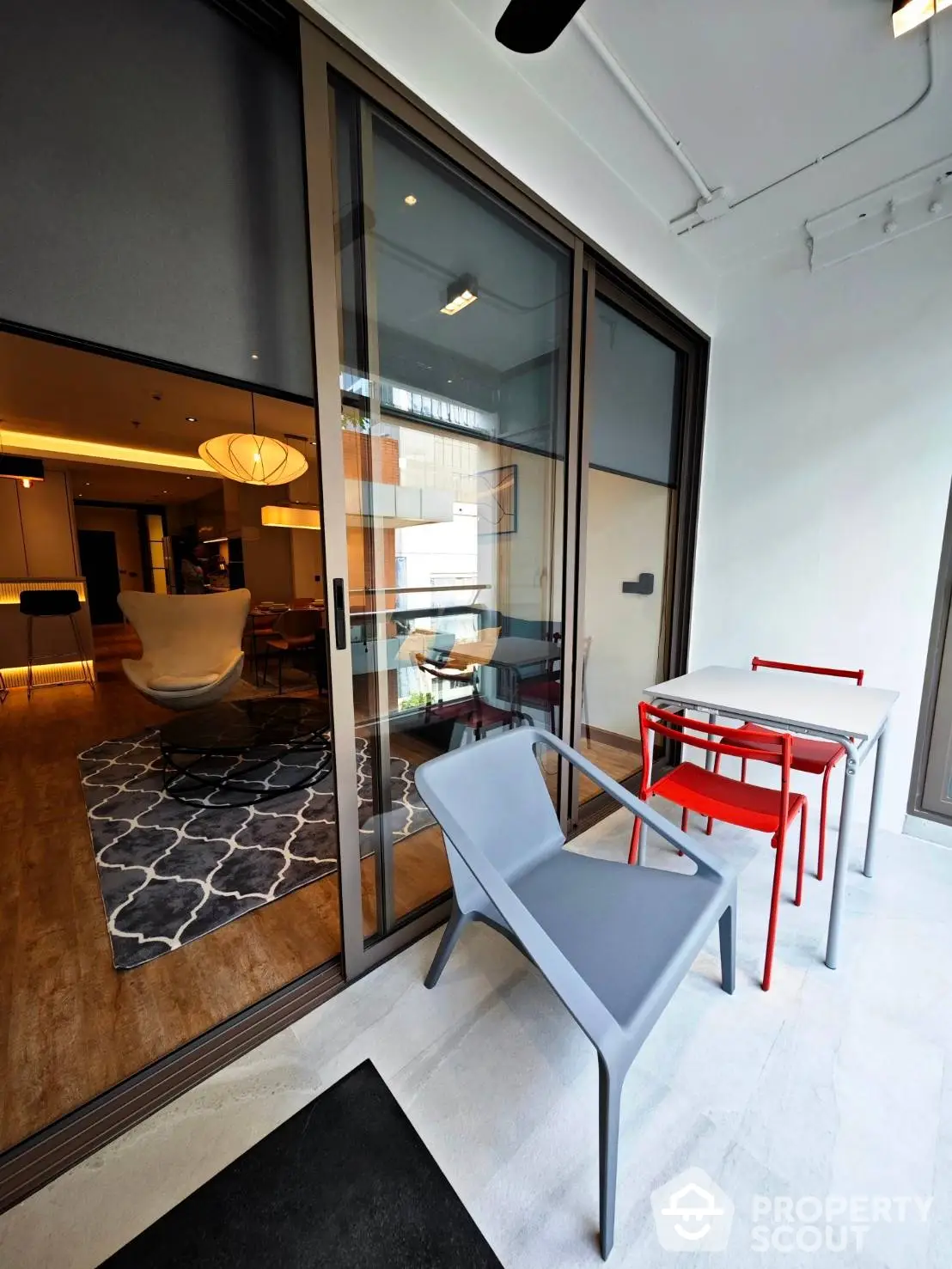 Chic modern balcony with stylish furniture overlooking an elegant interior living space, perfect for urban living.