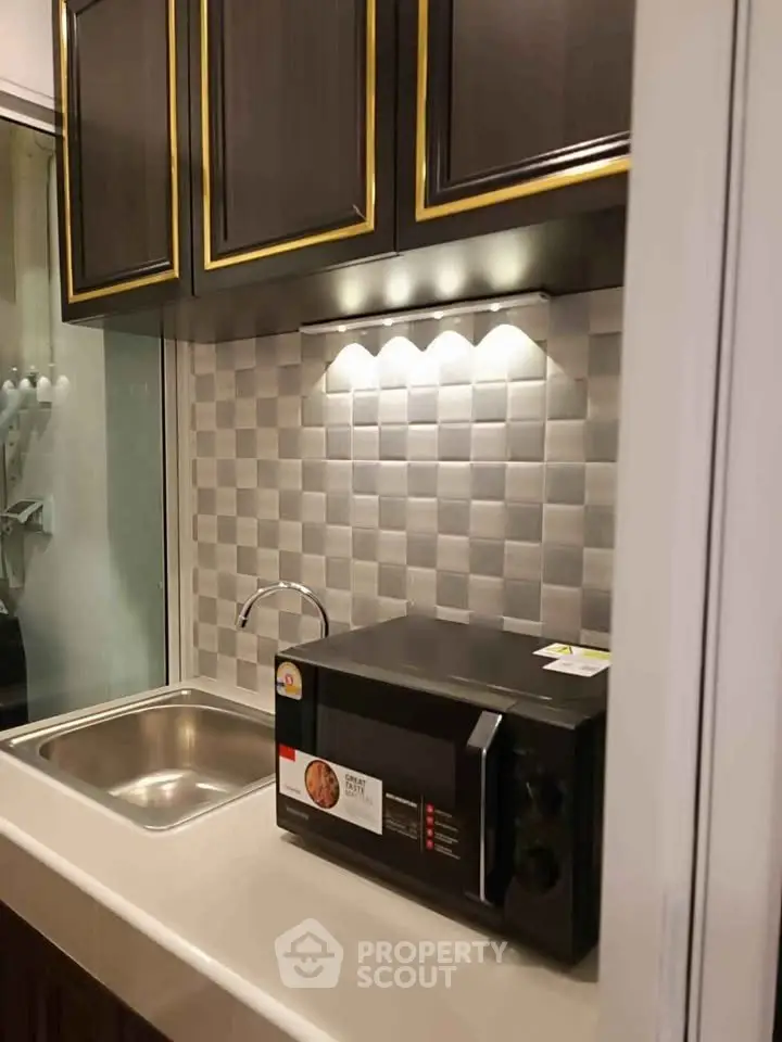 Modern compact kitchen with sleek cabinetry and built-in microwave