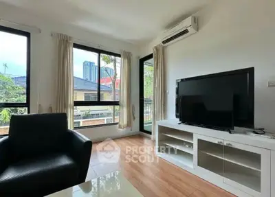 Bright living room with modern furnishings and large windows offering a city view.