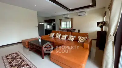Spacious living room with modern leather sofa and open kitchen layout