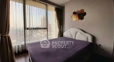 Spacious bedroom with large windows offering stunning city views
