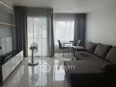 Modern living room with sleek furniture and large windows offering natural light.