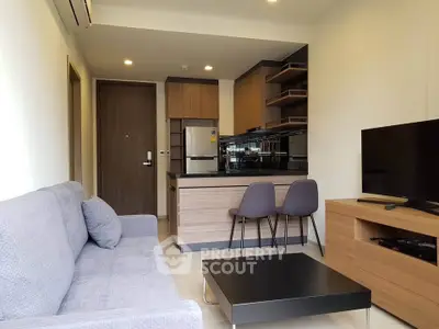 Modern open-plan living room with kitchen, featuring sleek furniture and contemporary design.