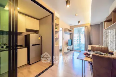 Modern open-plan living room with kitchen and dining area, featuring stylish decor and natural light.
