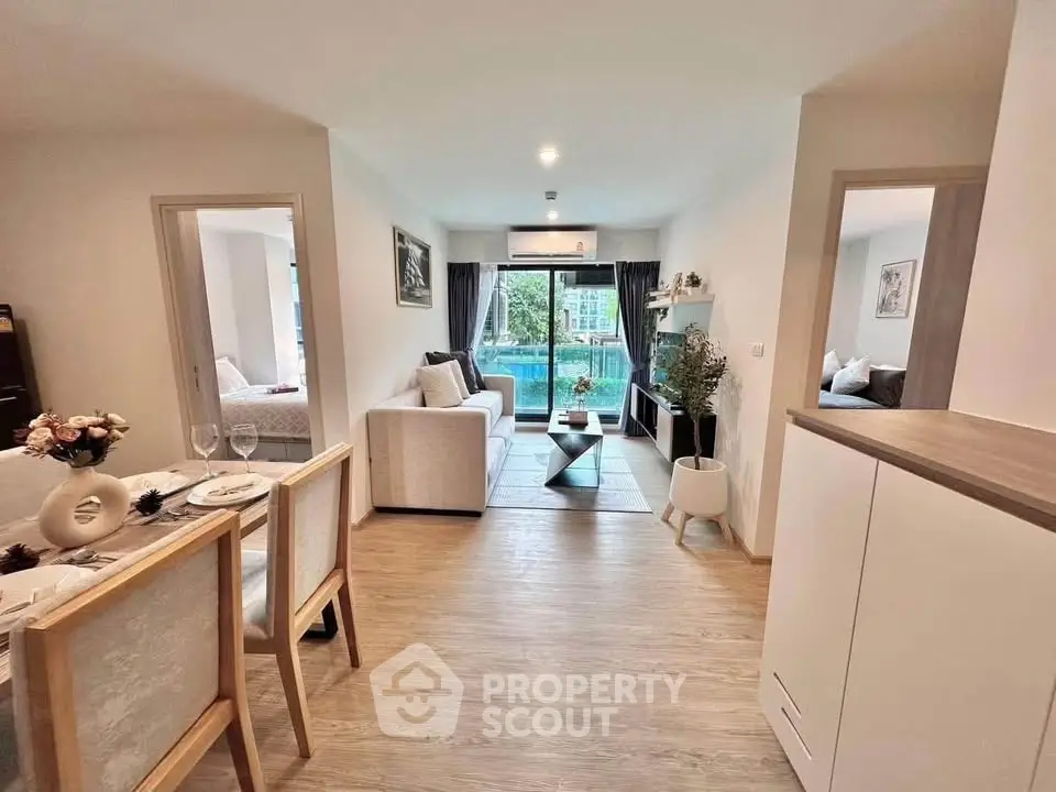Modern open-plan living room with dining area and pool view, featuring stylish decor and natural light.