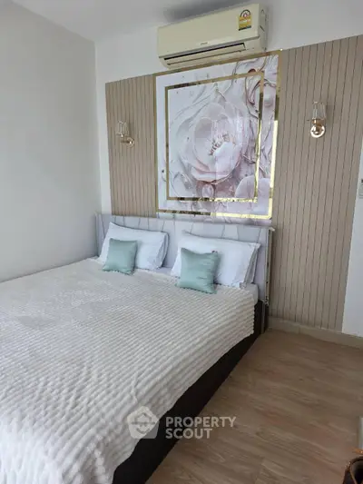 Elegant bedroom with modern decor and air conditioning, featuring a stylish floral artwork above the bed.