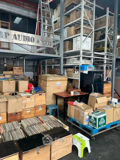 Spacious storage area with shelves filled with boxes and audio equipment, ideal for warehouse needs.