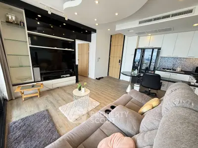 Modern living room with open kitchen, stylish decor, and cozy seating in a contemporary apartment.