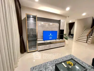 Modern living room with sleek entertainment center and staircase