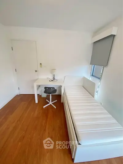 Minimalist bedroom with single bed and study desk, perfect for a cozy and functional living space.