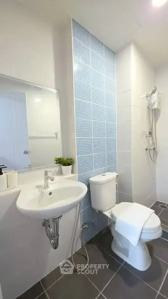 Modern bathroom with sleek fixtures and stylish blue tile accent wall.
