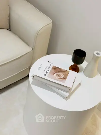 Stylish modern living room corner with elegant round table and cozy beige sofa.