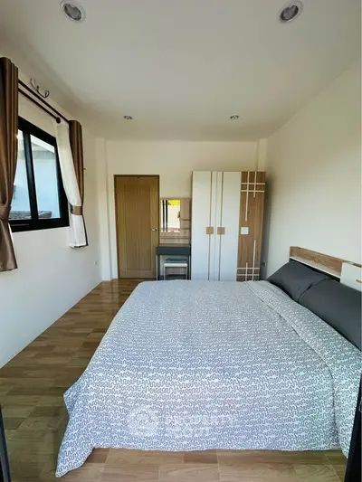 Spacious bedroom with modern decor and natural light, featuring a comfortable bed and stylish wardrobe.