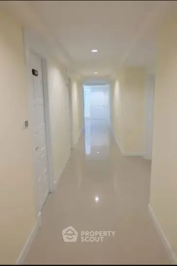 Bright and spacious hallway with glossy floors in modern building