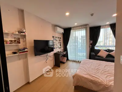 Cozy bedroom with modern decor, featuring a wall-mounted TV, air conditioning, and a large window with city view.