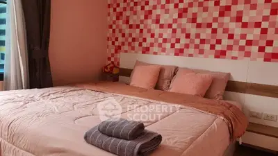 Cozy bedroom with stylish pink decor and comfortable bedding in modern apartment.