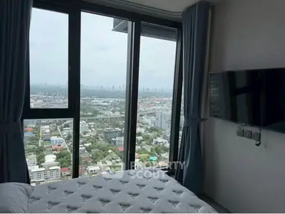 Stunning bedroom with panoramic city view from high-rise window, featuring modern decor and wall-mounted TV.