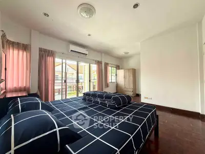Spacious bedroom with balcony access and modern decor in a bright, airy apartment.