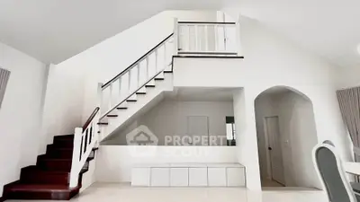 Spacious modern living room with elegant staircase and minimalist design.