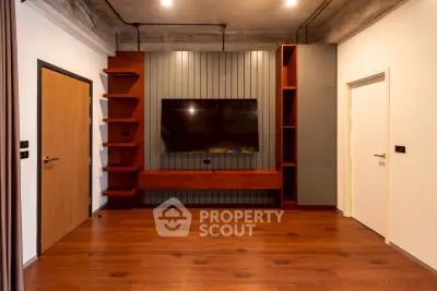 Modern living room with stylish wooden flooring and built-in TV unit, perfect for contemporary living.