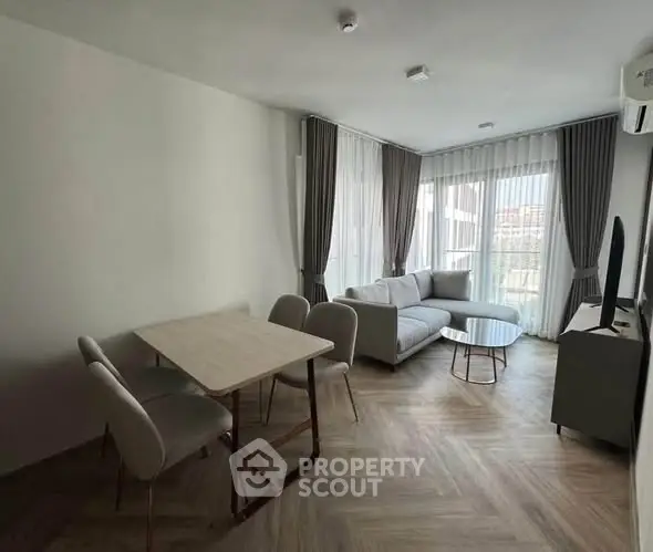 Modern living room with stylish furniture and large windows offering natural light.