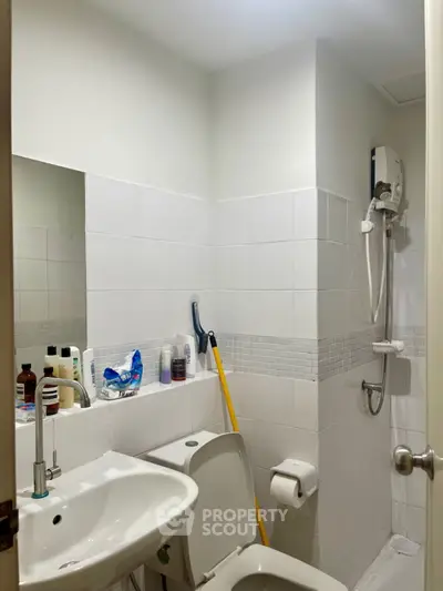 Compact bathroom with shower, sink, and toilet in a modern apartment.