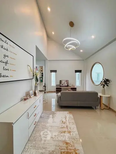 Elegant living room with modern decor, stylish chandelier, and cozy seating area.