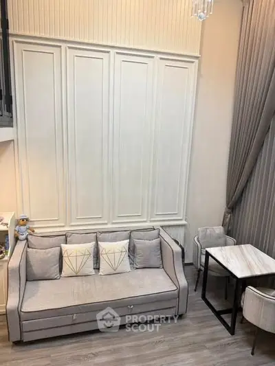 Elegant living room with high ceilings, modern sofa, and dining area in stylish apartment.