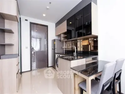 Modern kitchen with sleek cabinetry and dining area in a stylish apartment.
