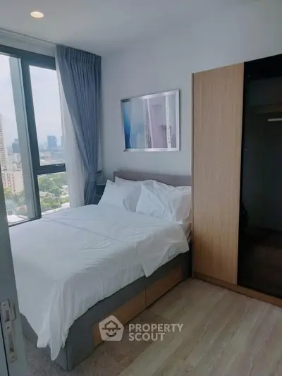 Modern bedroom with city view, featuring a cozy bed and stylish decor in a high-rise apartment.