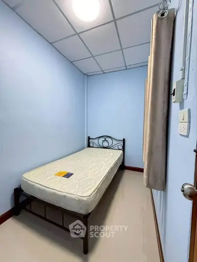 Cozy small bedroom with single bed and minimalist decor, perfect for compact living spaces.