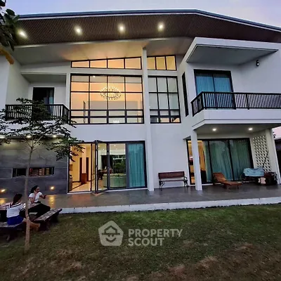 Stunning modern two-story house with large windows and elegant balcony, perfect for luxurious living.