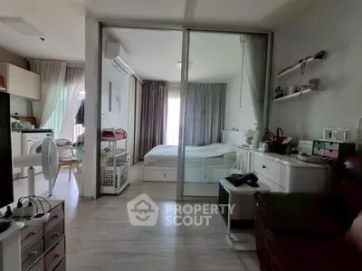 Modern studio apartment with glass partition, cozy bedroom, and stylish decor.