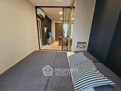 Modern bedroom with stylish decor and view into a chic living area, featuring sleek design and cozy ambiance.