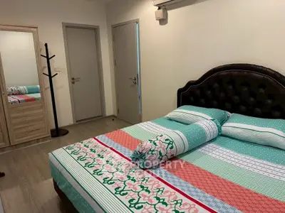 Cozy bedroom with stylish bed and mirrored wardrobe, perfect for relaxation.