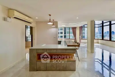 Spacious modern living room with open layout and city view, featuring sleek design and ample natural light.