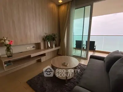 Modern living room with ocean view balcony, cozy seating, and elegant decor.