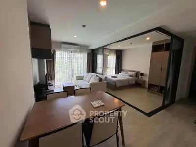 Modern studio apartment with open layout, featuring a cozy living area and bedroom with large windows.