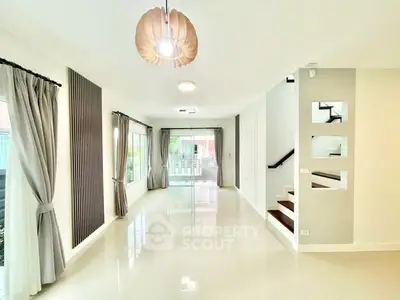 Spacious modern living room with large windows and elegant lighting