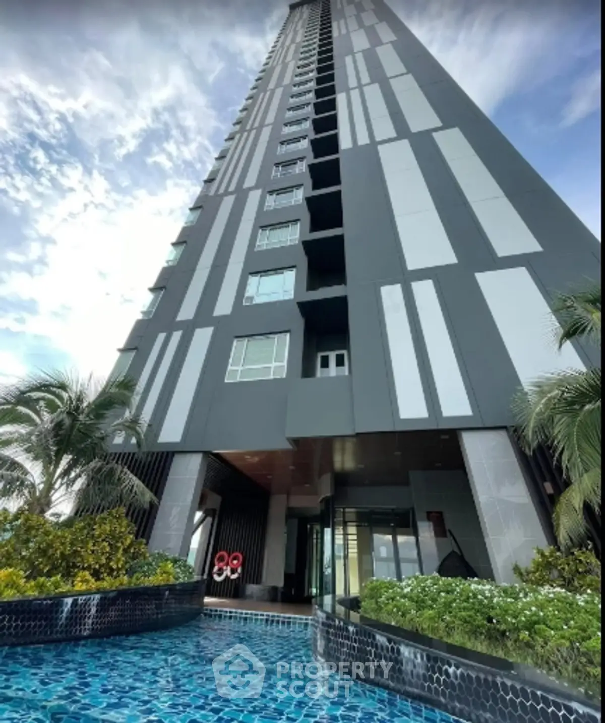 Stunning modern high-rise building with pool and lush landscaping, perfect for luxury urban living.