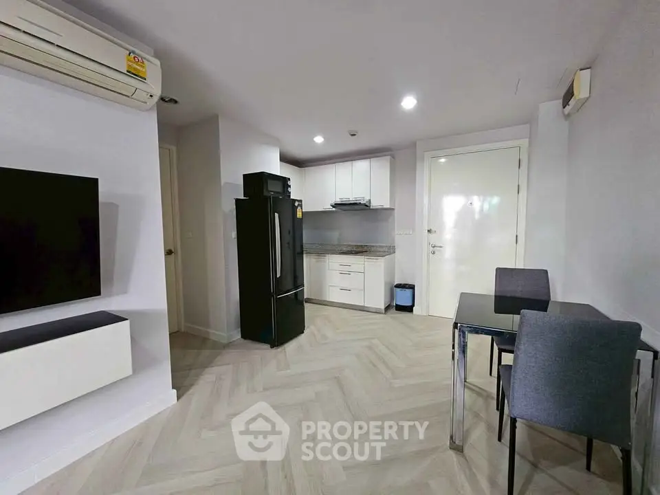 Modern apartment interior with sleek kitchen and dining area, featuring stylish flooring and contemporary appliances.