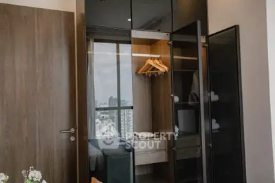 Modern bedroom with sleek wardrobe and city view, perfect for urban living.
