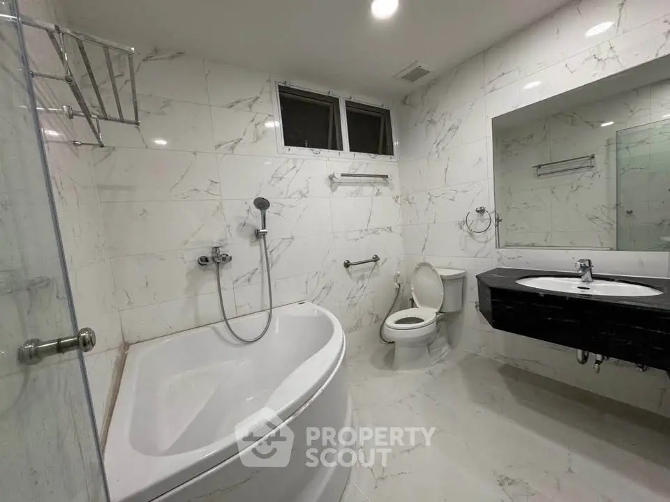 Luxurious marble bathroom with modern fixtures and corner bathtub