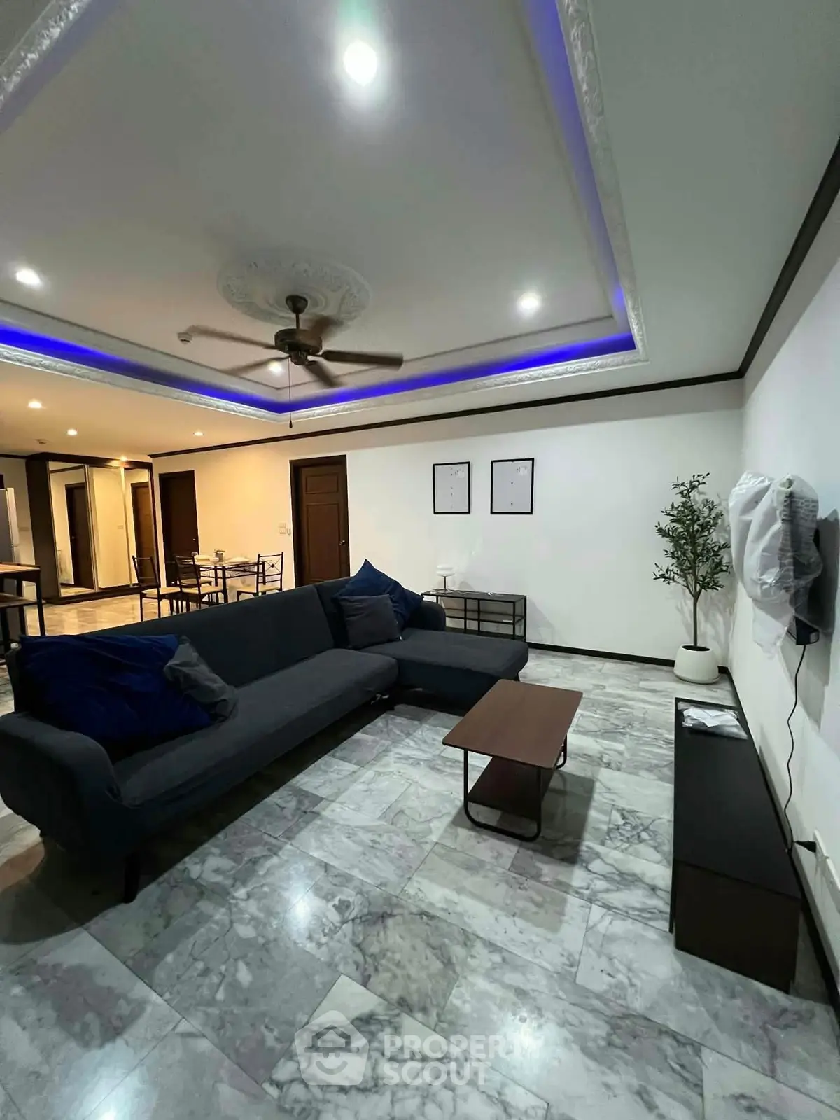 Spacious living room with modern decor and marble flooring in a stylish apartment.