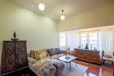 Charming living room with cozy seating and elegant decor, featuring large windows for natural light.