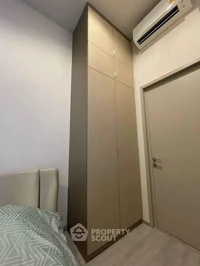 Modern bedroom with sleek wardrobe and air conditioning unit, perfect for comfortable living.