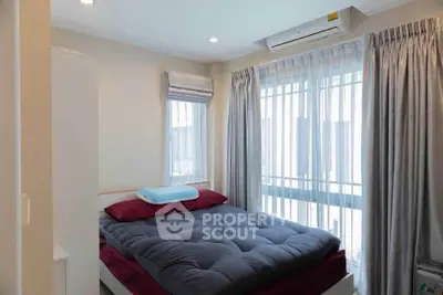Cozy bedroom with large window and modern air conditioning unit, perfect for relaxation.