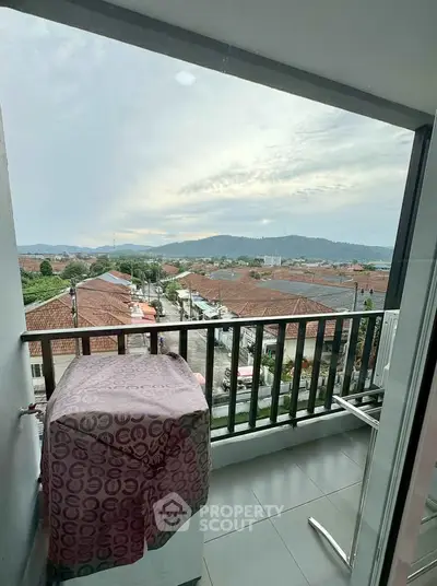 Charming balcony with scenic view of rooftops and hills, perfect for relaxation and enjoying the outdoors.